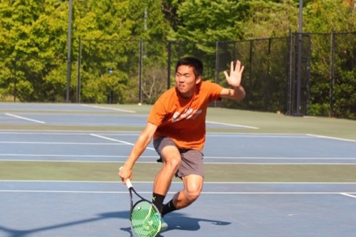 Albert hitting a forehand on an outdoor hard court